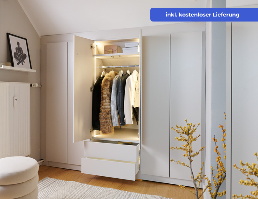 Großer Einbau-Kleiderschrank. Dekor: Weiß. Links und rechts eine durchgehende, geschlossene Flügeltür. Das Element in der Mitte hat eine geöffnete Flügeltür. Gezeigt wird oben ein Ausziehelement mit Kästen/Behältern. Mittig eine Kleiderstange mit Pullovern und Jacken. Darunter zwei leicht geöffnete Schubladen. Das Element ist oberhalb durch LED-Leisten links und rechts im Schrank beleuchtet. Der Raum ist überwiegend weiß gestaltet. Weißes Bett mit weißer-grauer Bettwäsche, Dekoelementen, hellem Hocker, hell gestreifter Teppich vor dem Schrank. Weiße Paneel hinter dem Bett und eine weiße Heizung an der Wand.