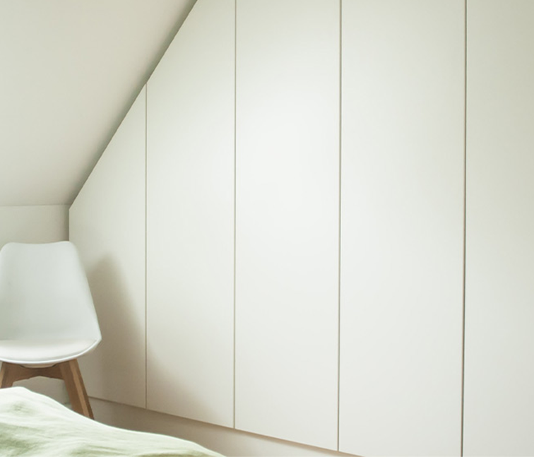 Weißer Schrank mit Schräge in der Nische