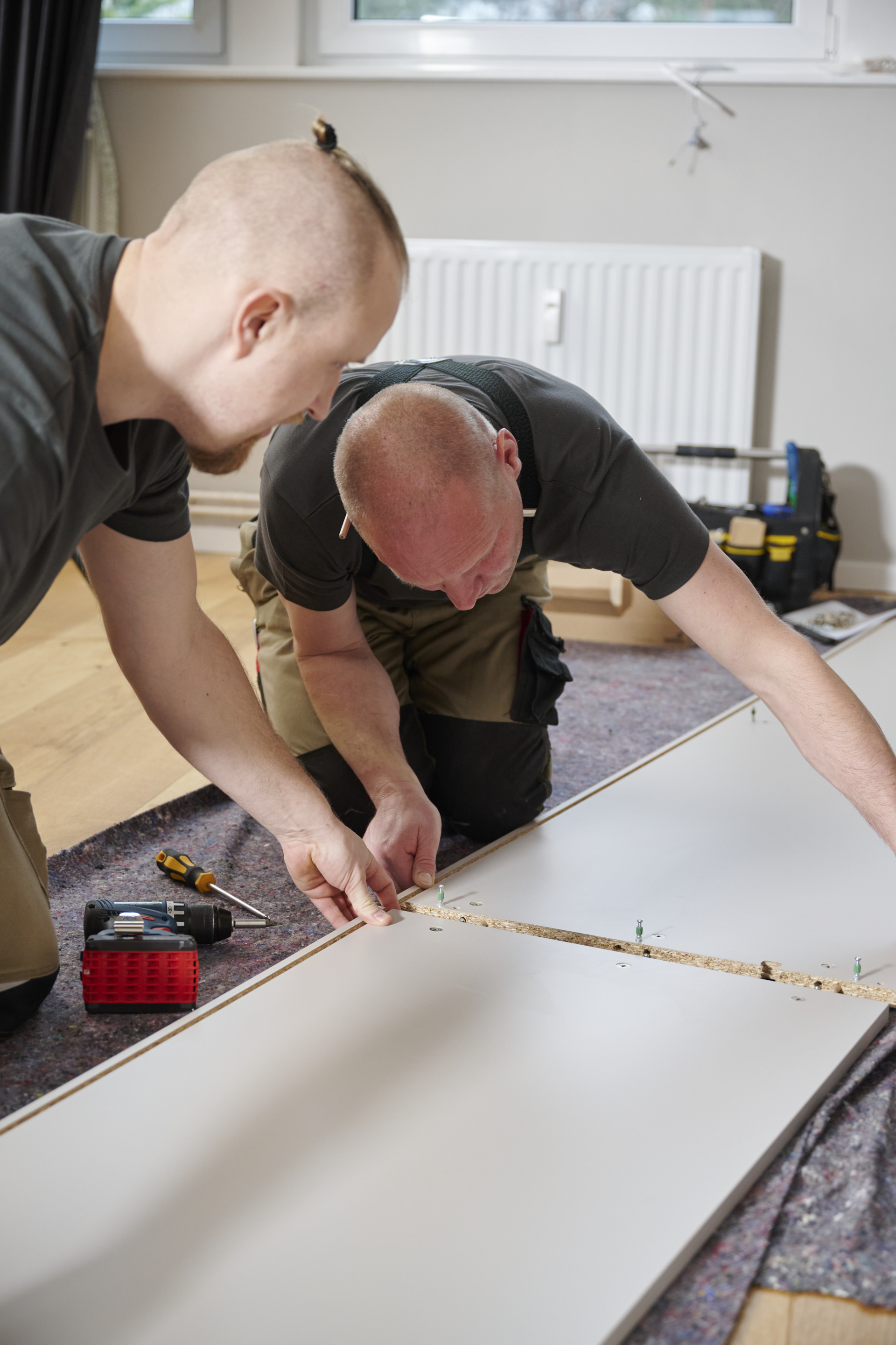 Zwei Monteure beim Aufbau eines Schranks